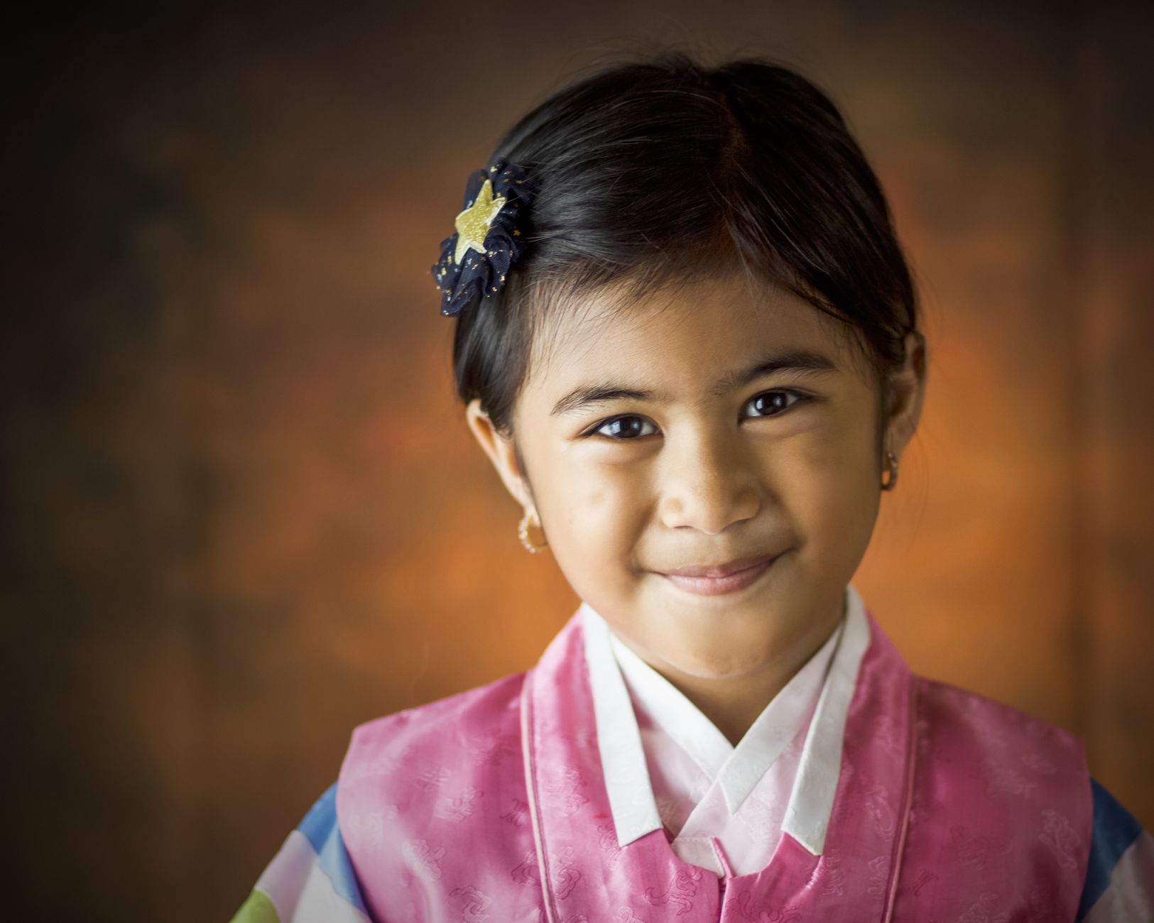 child wearing small silver earrings smiling