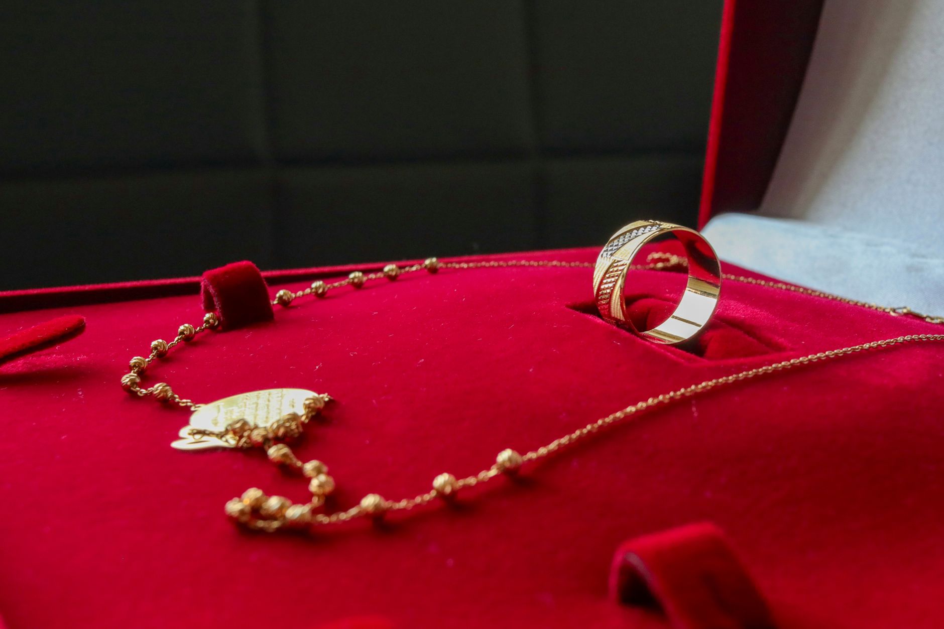woman placing gold necklace in luxury velvet jewelry box