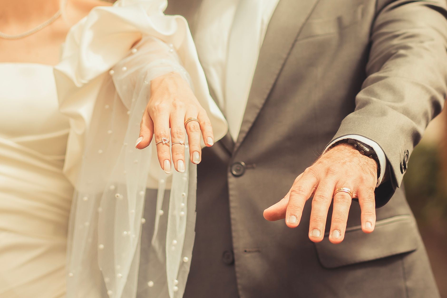 bride and groom hands with wedding rings golden white gold