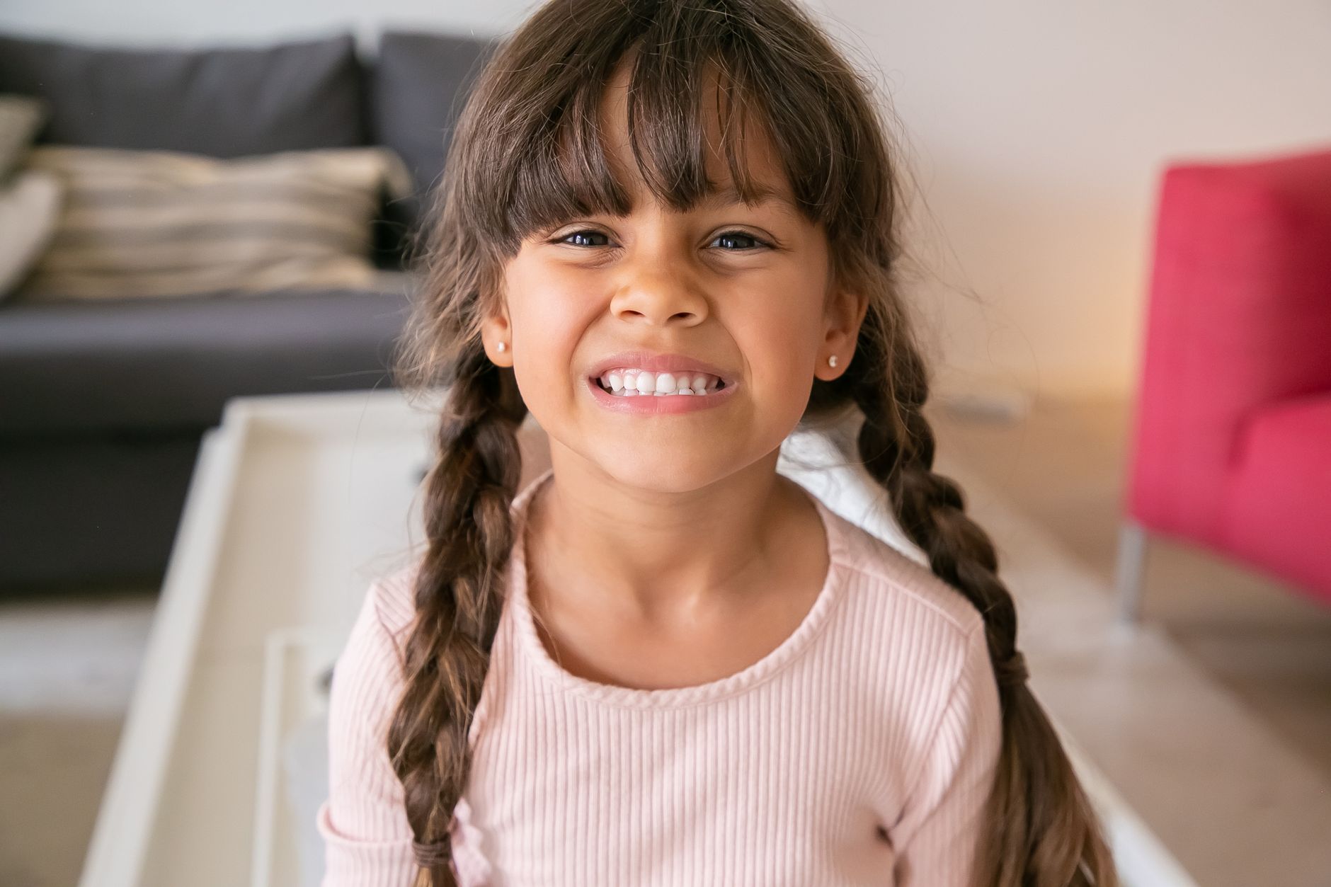 child wearing simple gold stud earrings smiling