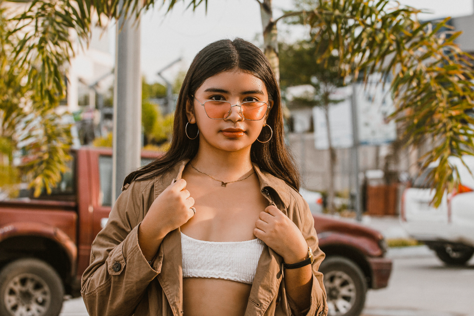 teenage girl wearing delicate gold necklace and hoop earrings